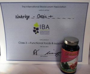 bottle of Cassis+ by Naturege standing in front of the award for functional foods from the blackcurrant contest 2016