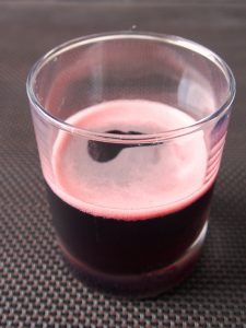 glass half filled with blackcurrant juice