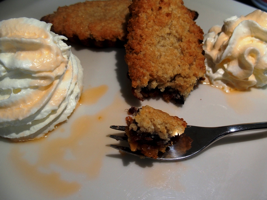 2 blackcurrant Christmas Mince Pies with a small fork and whipped cream