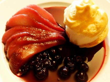 plate with a profiterole, pear in blackcurrant and red wine sauce