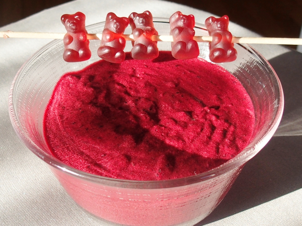 picture showing a bowl of blackcurrant mousse, decorated with blackcurrant gummybears