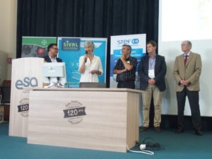 5 people standing behind a desk, Edith Giffard speaking at the blackcurrant products contest 2018