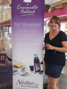 Emmanuelle Baillard standing beside one of the roll-ups of Nectars de Bourgogne