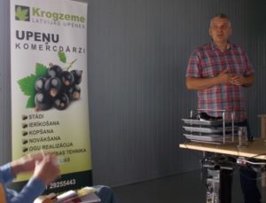 Andris Krogzems, standing beside a roll-up of Krogzeme farm