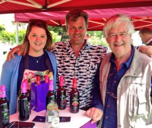 Booth of Pixley Berries, with owner Edward Thompson and two other persons standing with him behind his products