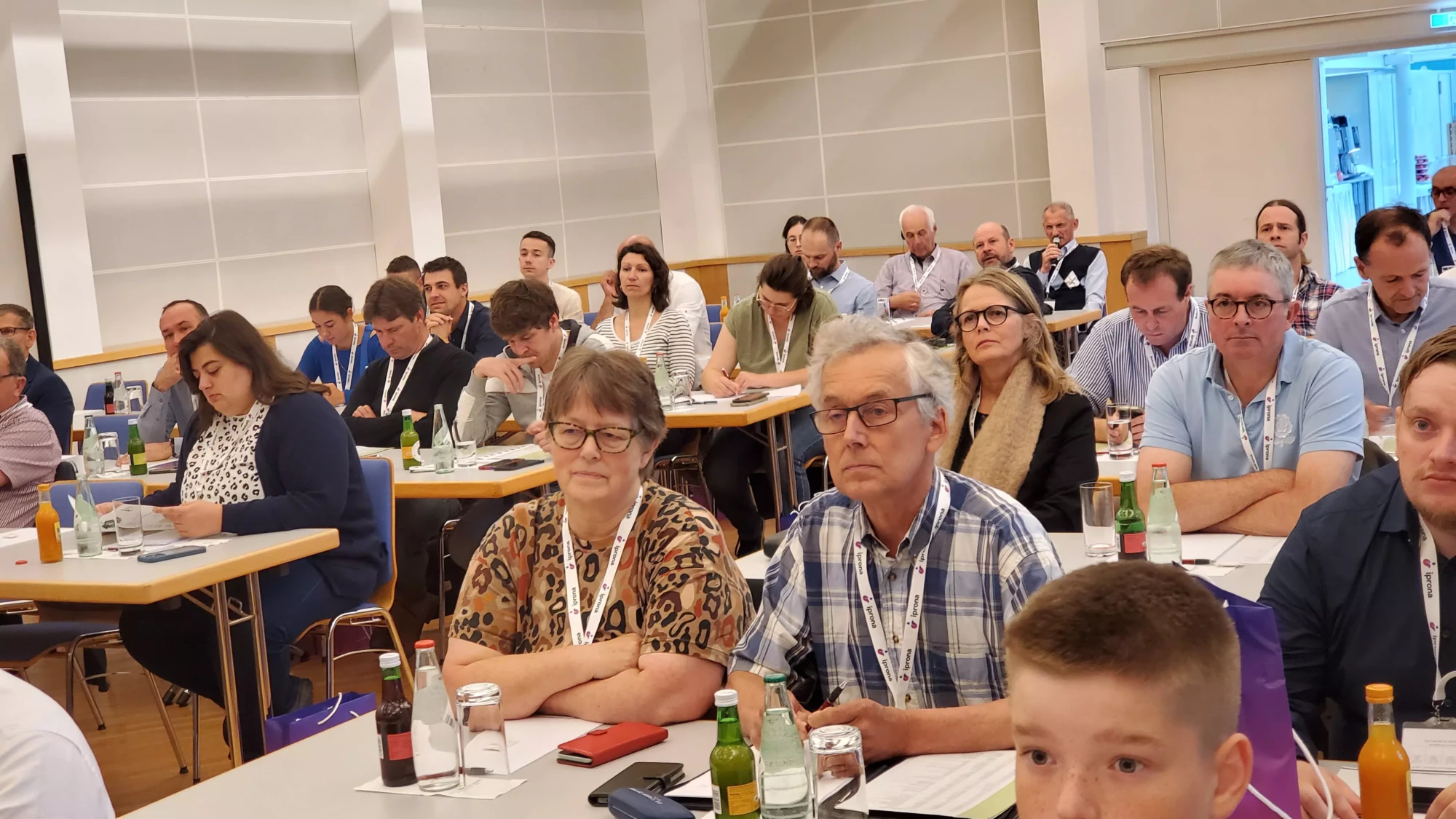 Attendees at an International Blackcurrant Association (IBA) conference, seated at tables, symbolizing the global collaboration and administrative transition of the IBA from New Zealand to France.