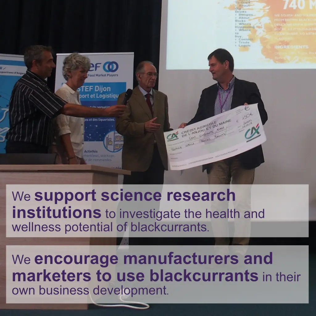 Group of professionals at an event, presenting a check to support blackcurrant research and encourage its use in business development.